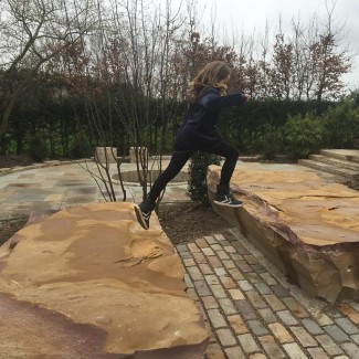 Pige laver parkour på sandstensblokke